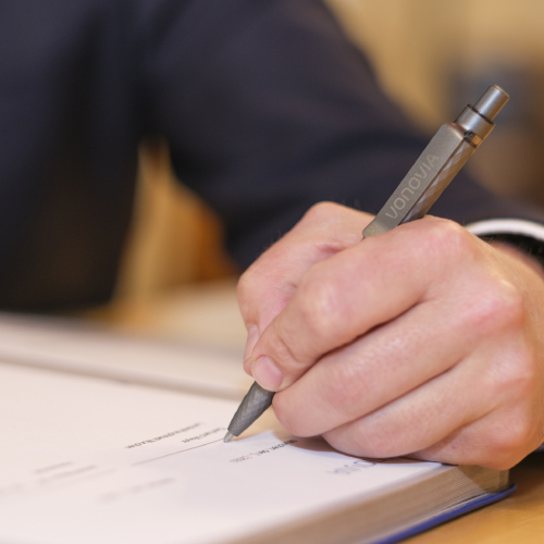 Eine Hand schreibt etwas in ein Buch. Eine Hand schreibt etwas in ein Buch.