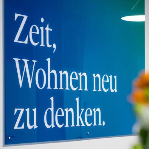 Blaues Schild zeigt Text: Zeit, Wohnen neu zu denken.