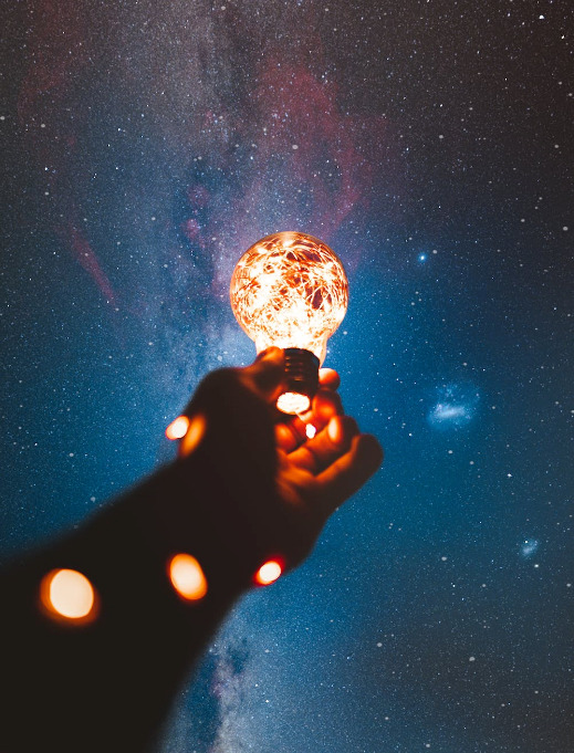 Hand hält eine Glühbirne.