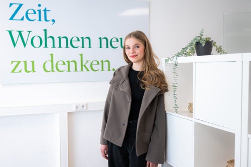 Eine Auszubildende steht in einem Büro.