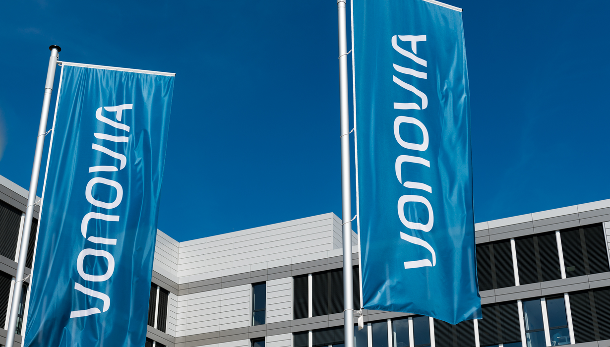 Zwei blaue Vonovia Flaggen vor einem Gebäude.