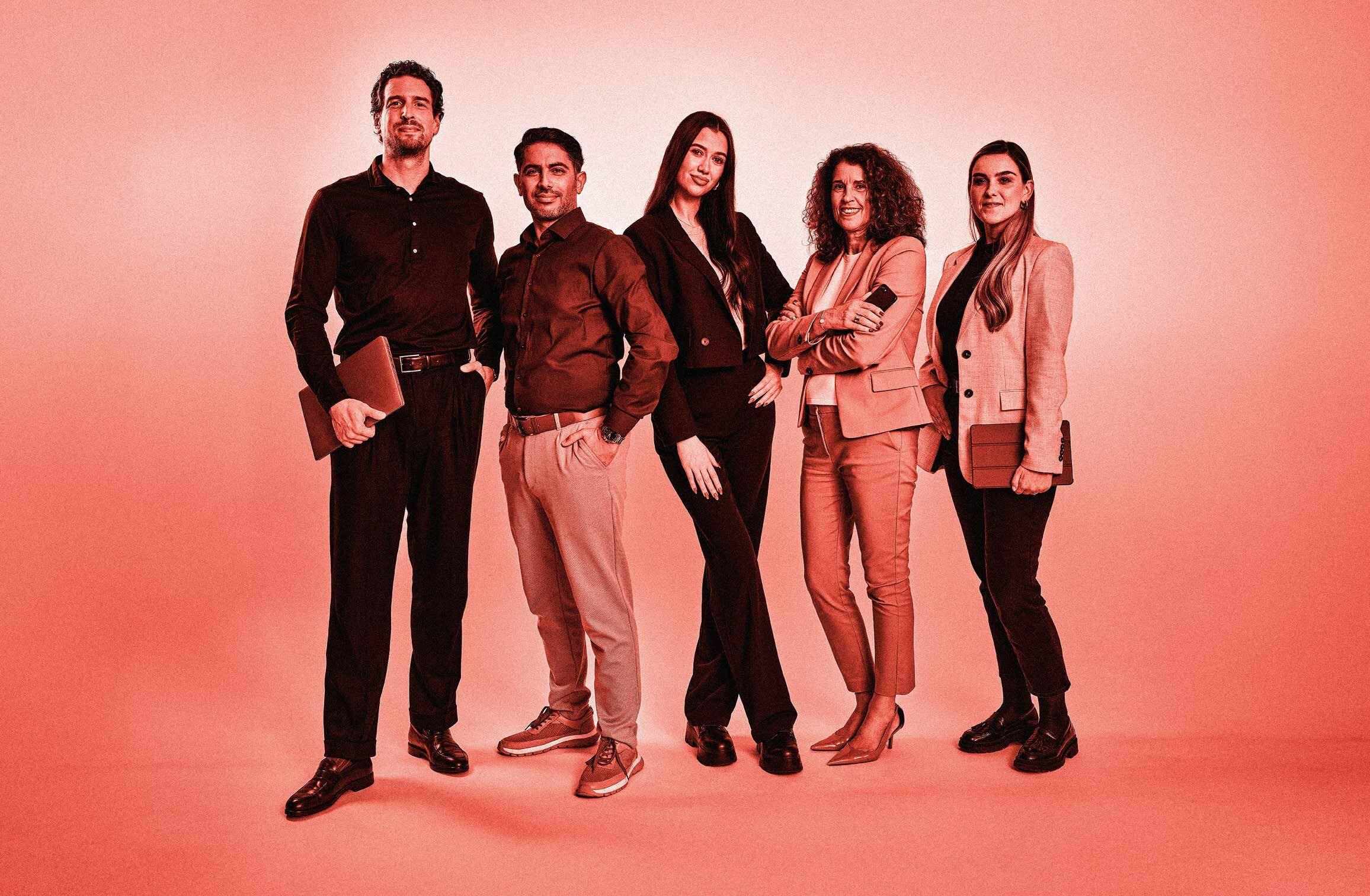 Fünf Mitarbeitende in Business-Kleidung posieren. Roter Filter über dem gesamten Bild.
