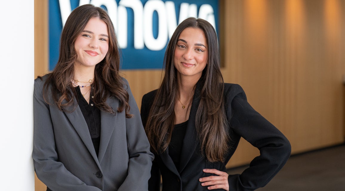 Zwei Auszubildende stehen vor einem Vonovia Schild.