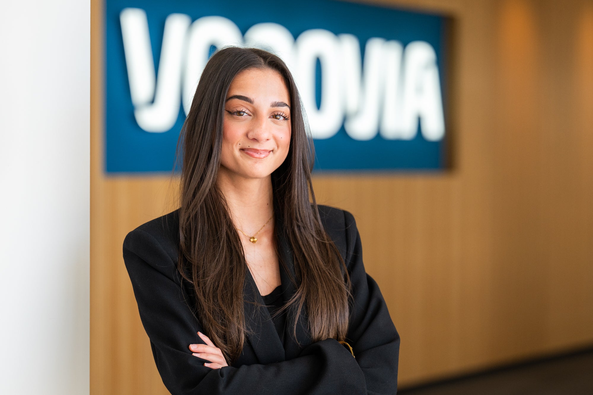 Eine Auszubildende steht lächelnd vor einem Vonovia Schild.