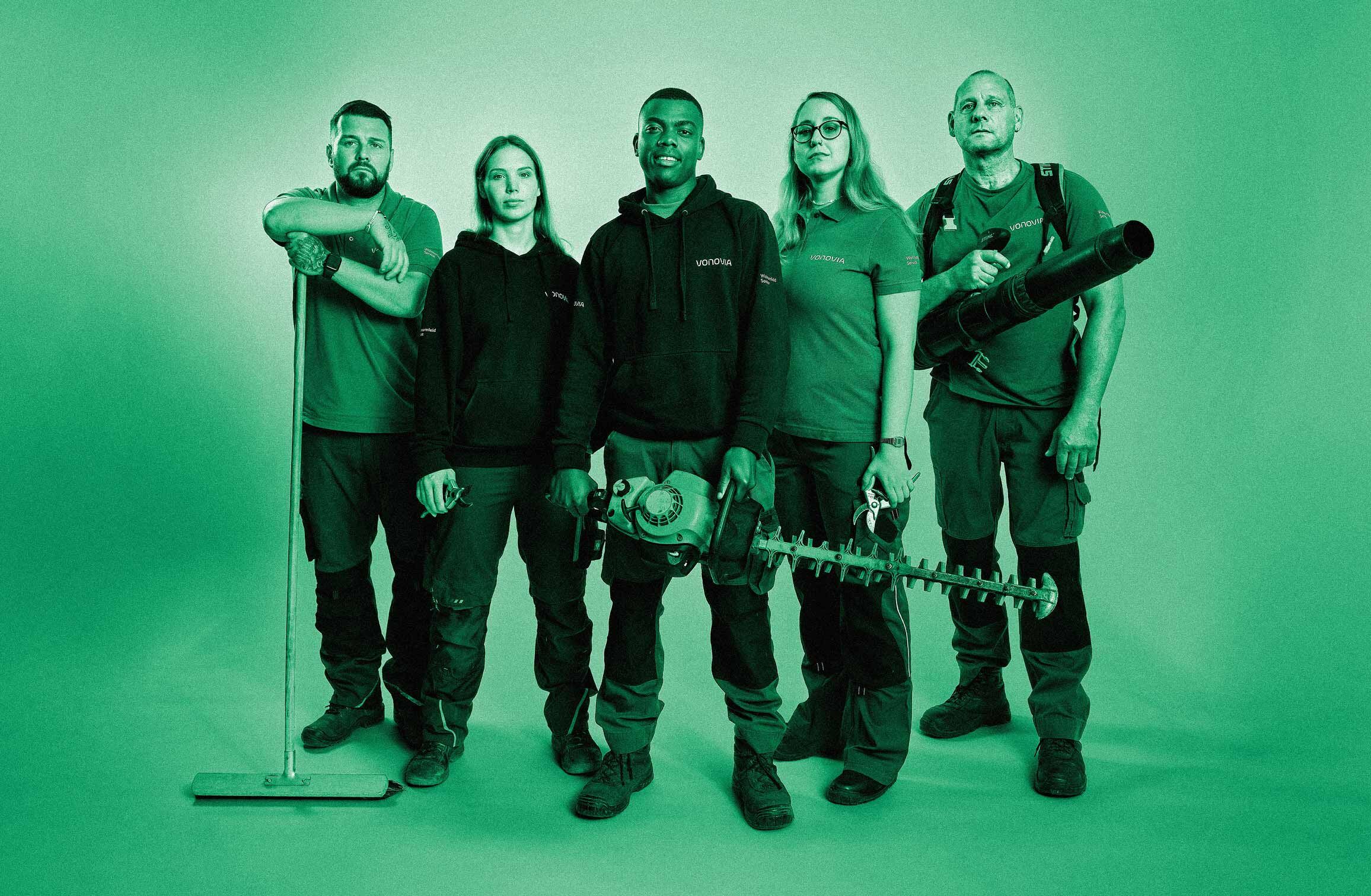 Fünf Mitarbeitende im Gartenbau posieren mit Ausstattung. Grüner Filter über dem gesamten Bild.