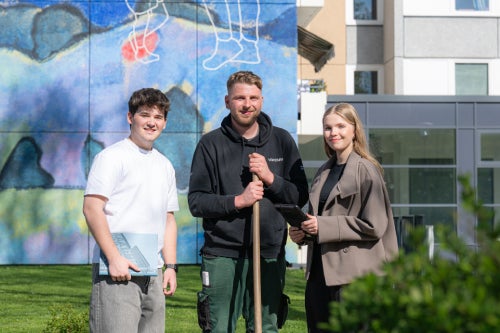 Drei Auszubildende stehen vor einem Vonovia Gebäude.