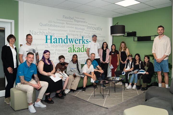 Gruppe von Jugendlichen in einem Raum, im Hintergrund Wand mit Text: Handwerksakademie.
