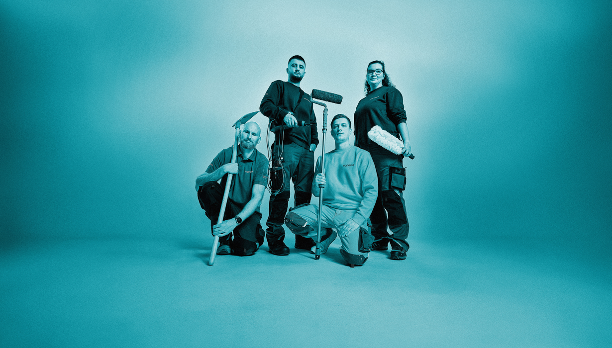 Vier Mitarbeitende posieren mit Arbeitsgeräten. Blauer Filter über gesamten Bild.